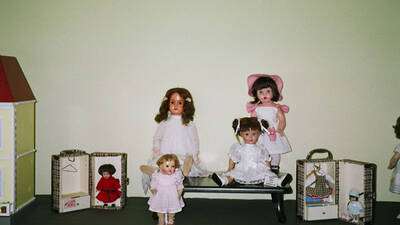 A la derecha, de rosa, Mariquita moderna. A su lado tres muñecas alemanas de principios del siglo XX. Flanquean la composición dos Mini-Mariquitas en sus cajas.