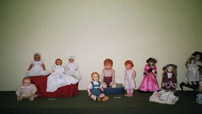 A la derecha, muñecas modernas de porcelana, vestidas de época. En el centro muñecas de cartón de los años 40-50
