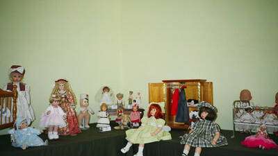 Mª Pepas con su vestuario. Al fondo en el rincón, muñecas de vinilo de los años 50. A la izquierda muñecas de porcelana